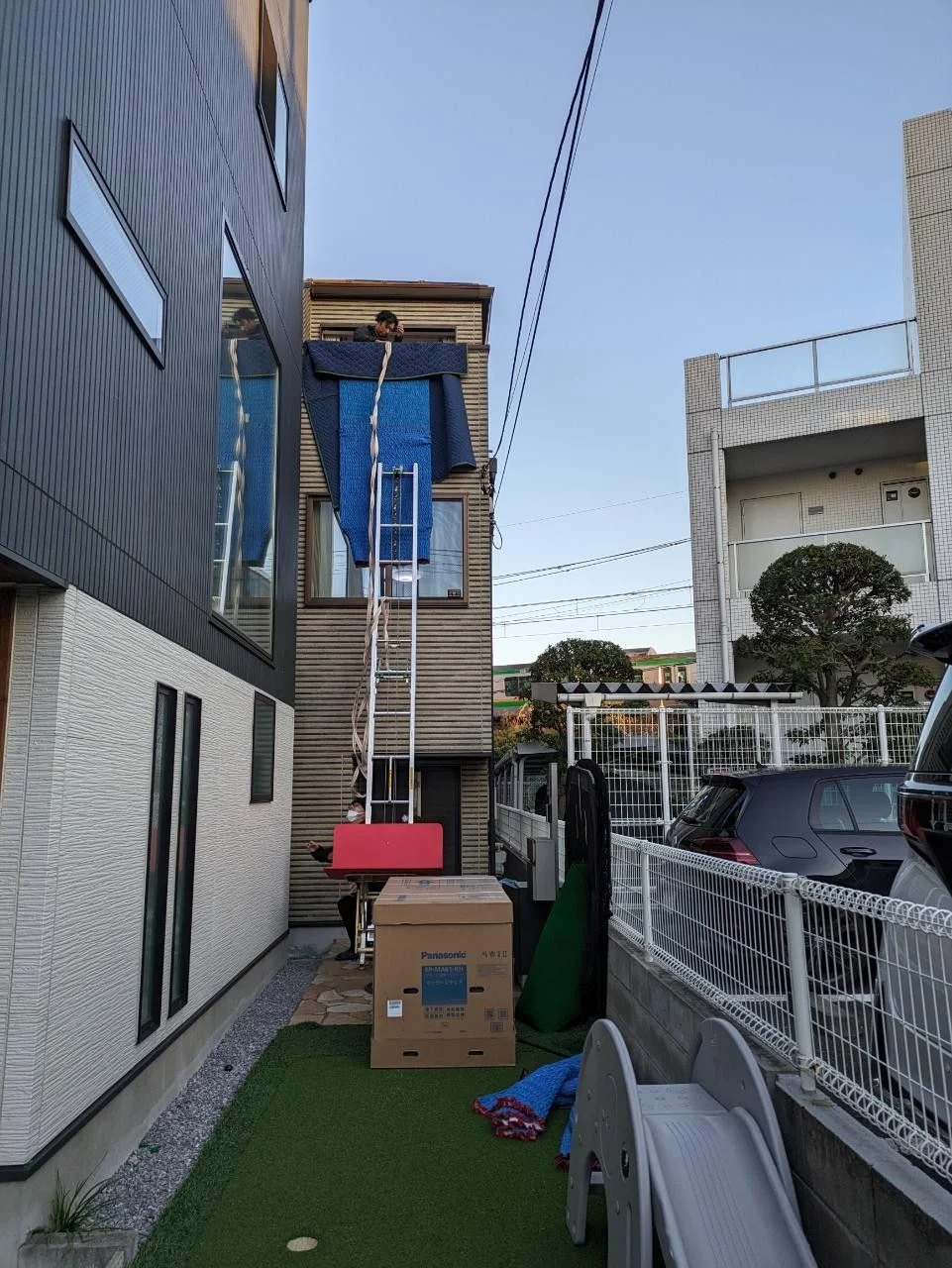 A mattress being hoisted to the third floor with ropes